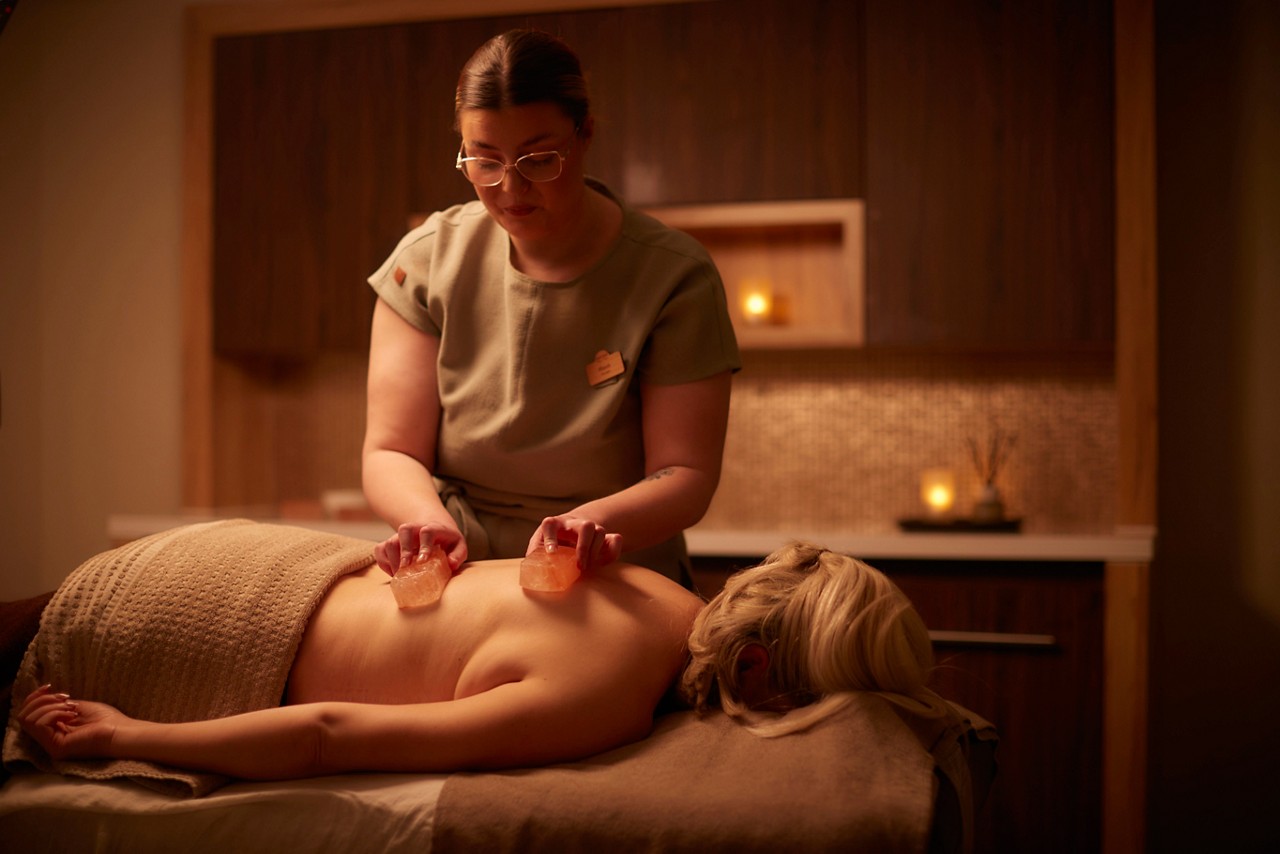 Spa therapist giving a women a relaxing face and body treatment.